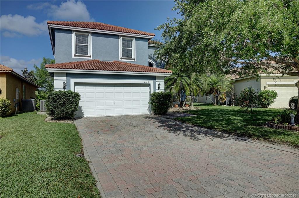 2120 Northwest Marsh Rabbit Lane Jensen Beach, FL 34957 - Photo 3 of 34 a front view of a house with a yard and garage