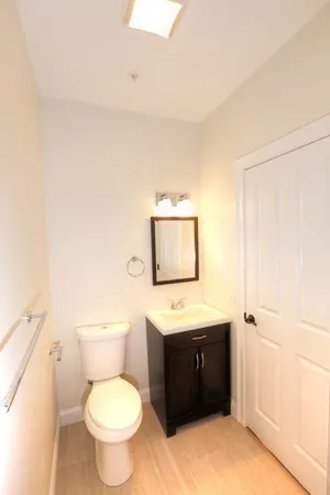 a bathroom with a toilet a sink and mirror