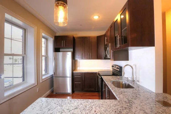 a kitchen with stainless steel appliances granite countertop a sink stove and refrigerator