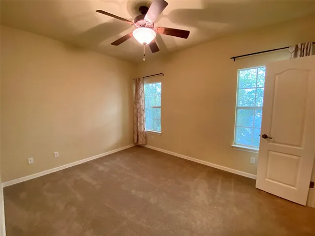 an empty room with closet and windows