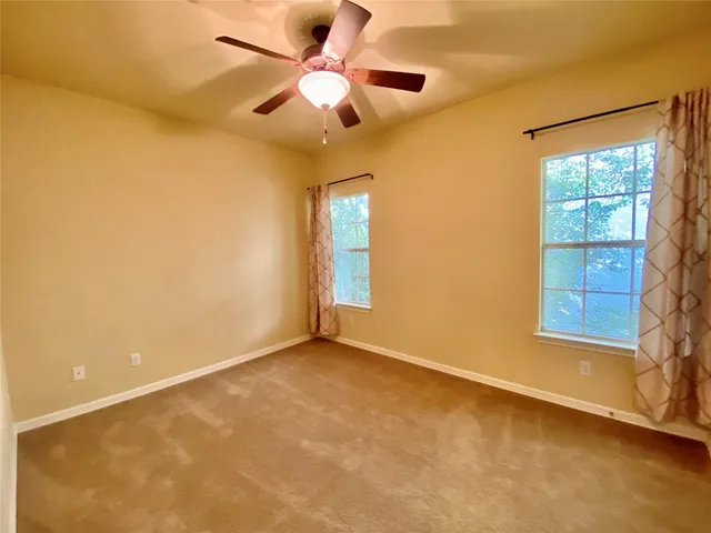 an empty room with a window and a fan