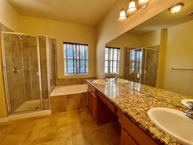 a spacious bathroom with a granite countertop tub sink and mirror
