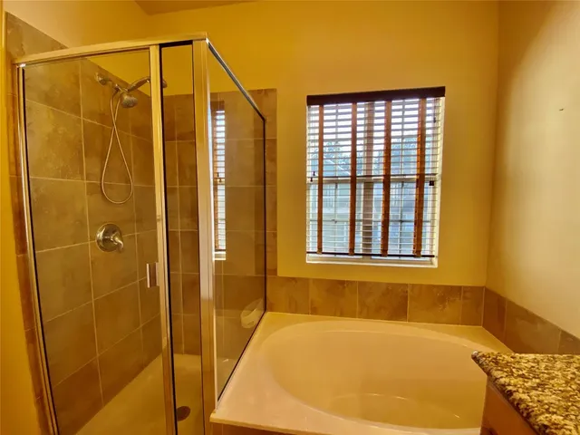 a bathroom with a bathtub and shower