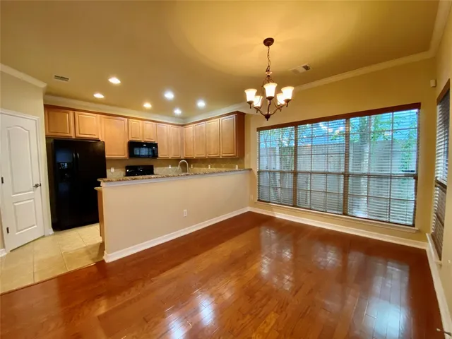 a large kitchen with granite countertop a large counter top stainless steel appliances and cabinets