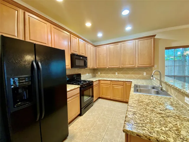 a large kitchen with granite countertop a large counter top stainless steel appliances and cabinets