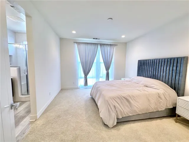 a bed sitting in a spacious bedroom next to a window