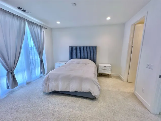 a spacious bedroom with a bed and a shower