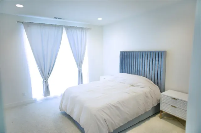 a large bed sitting in a bedroom next to a window