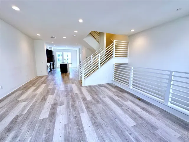 a view of a hallway with wooden floor and stairs