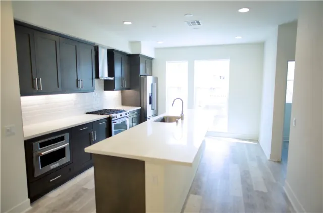 a kitchen with kitchen island a sink appliances and cabinets