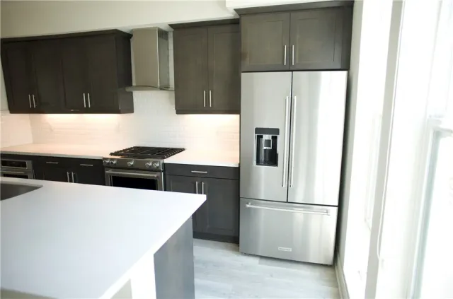 a kitchen with a refrigerator a stove and wooden cabinets