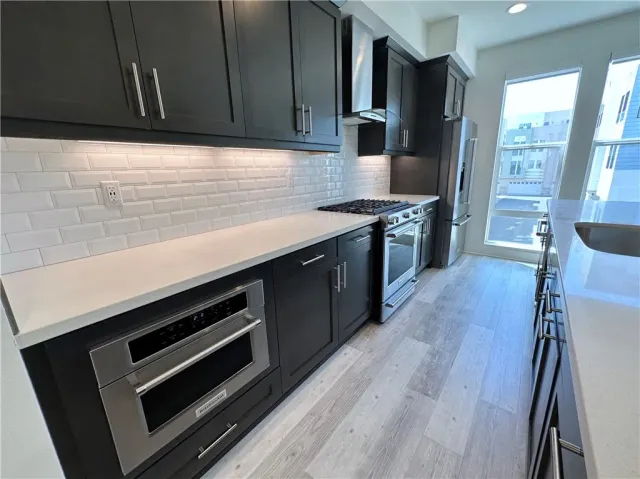 a kitchen with wooden cabinets stove and refrigerator