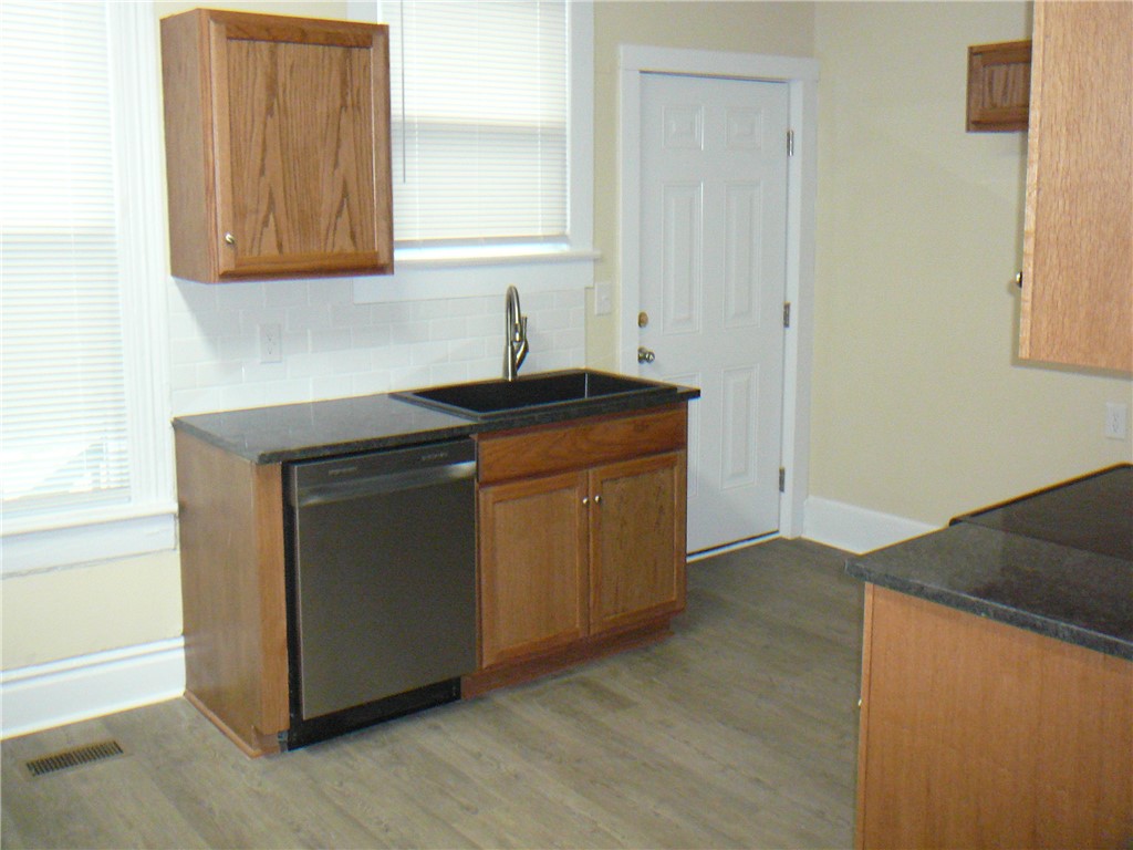 803 East Orr Street Anderson, SC 29621 - Photo 5 of 14 Warm wood cabinetry and dark stone counters define this classic kitchen layout.
