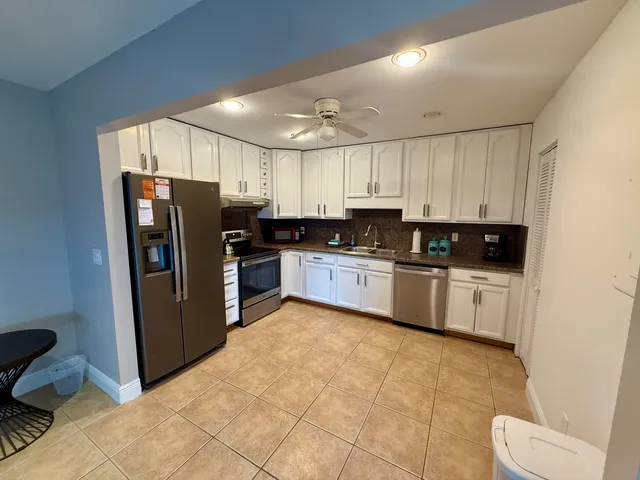 a kitchen with stainless steel appliances granite countertop a refrigerator sink and cabinets
