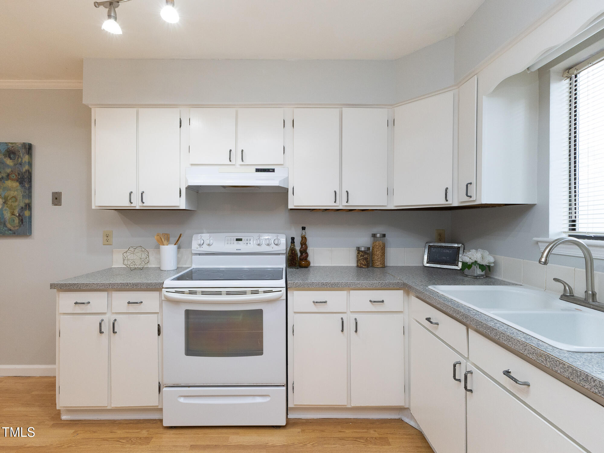 7353 Sandy Creek Drive Raleigh, NC 27615 - Photo 2 of 13 a kitchen with granite countertop white cabinets and white appliances