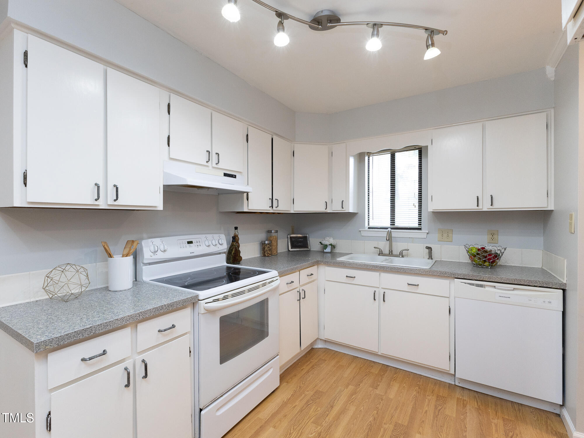 7353 Sandy Creek Drive Raleigh, NC 27615 - Photo 4 of 13 a kitchen with granite countertop white cabinets white appliances and sink