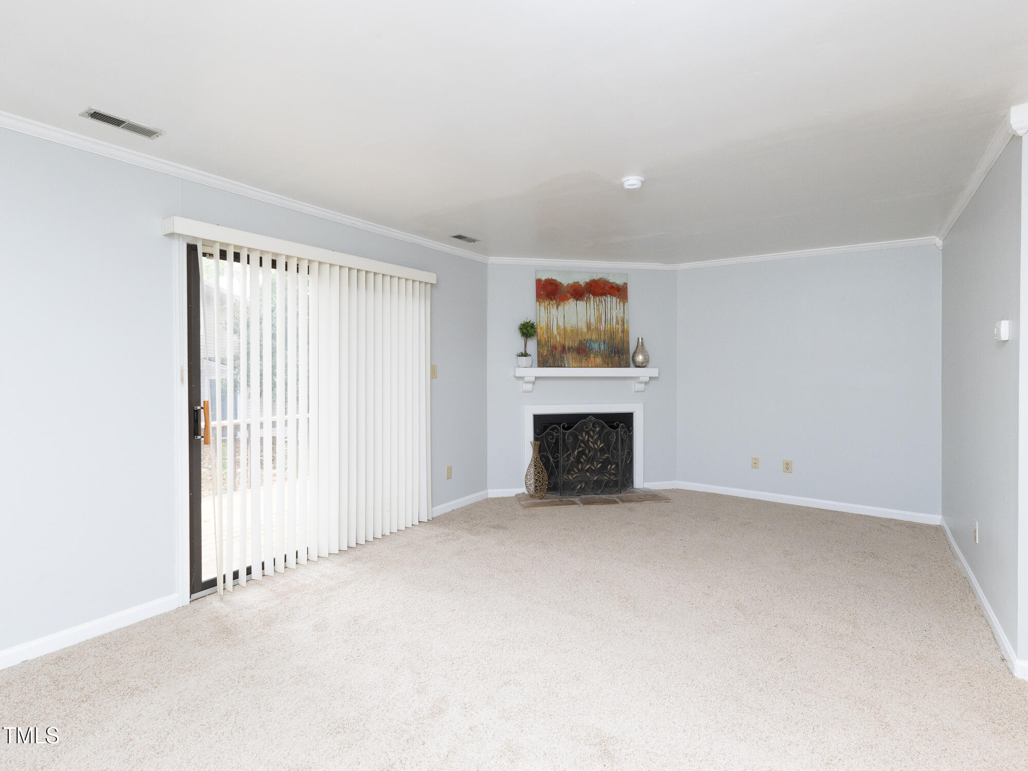 7353 Sandy Creek Drive Raleigh, NC 27615 - Photo 6 of 13 an empty room with a fireplace and a window