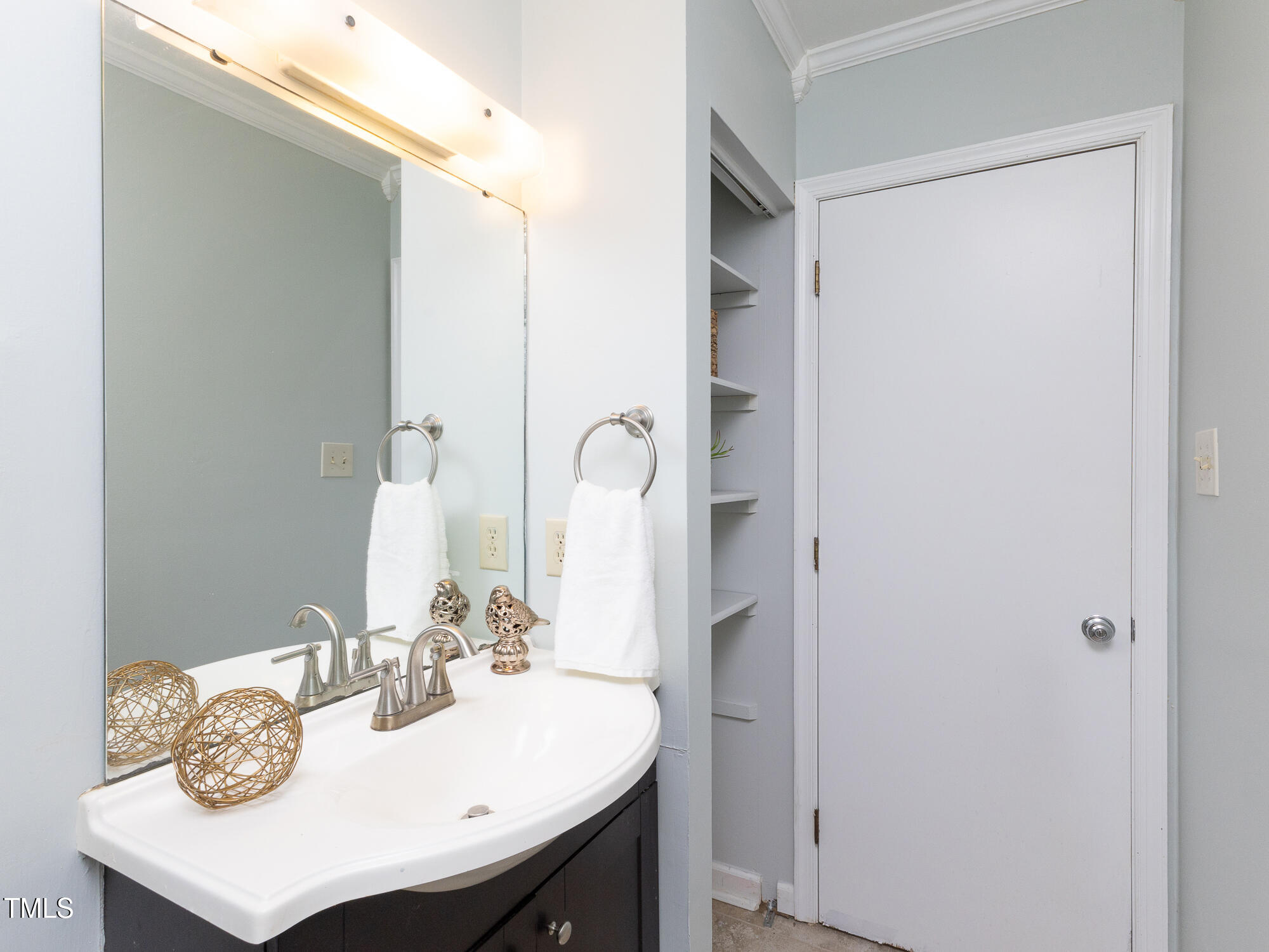 7353 Sandy Creek Drive Raleigh, NC 27615 - Photo 8 of 13 a bathroom with a sink and a mirror
