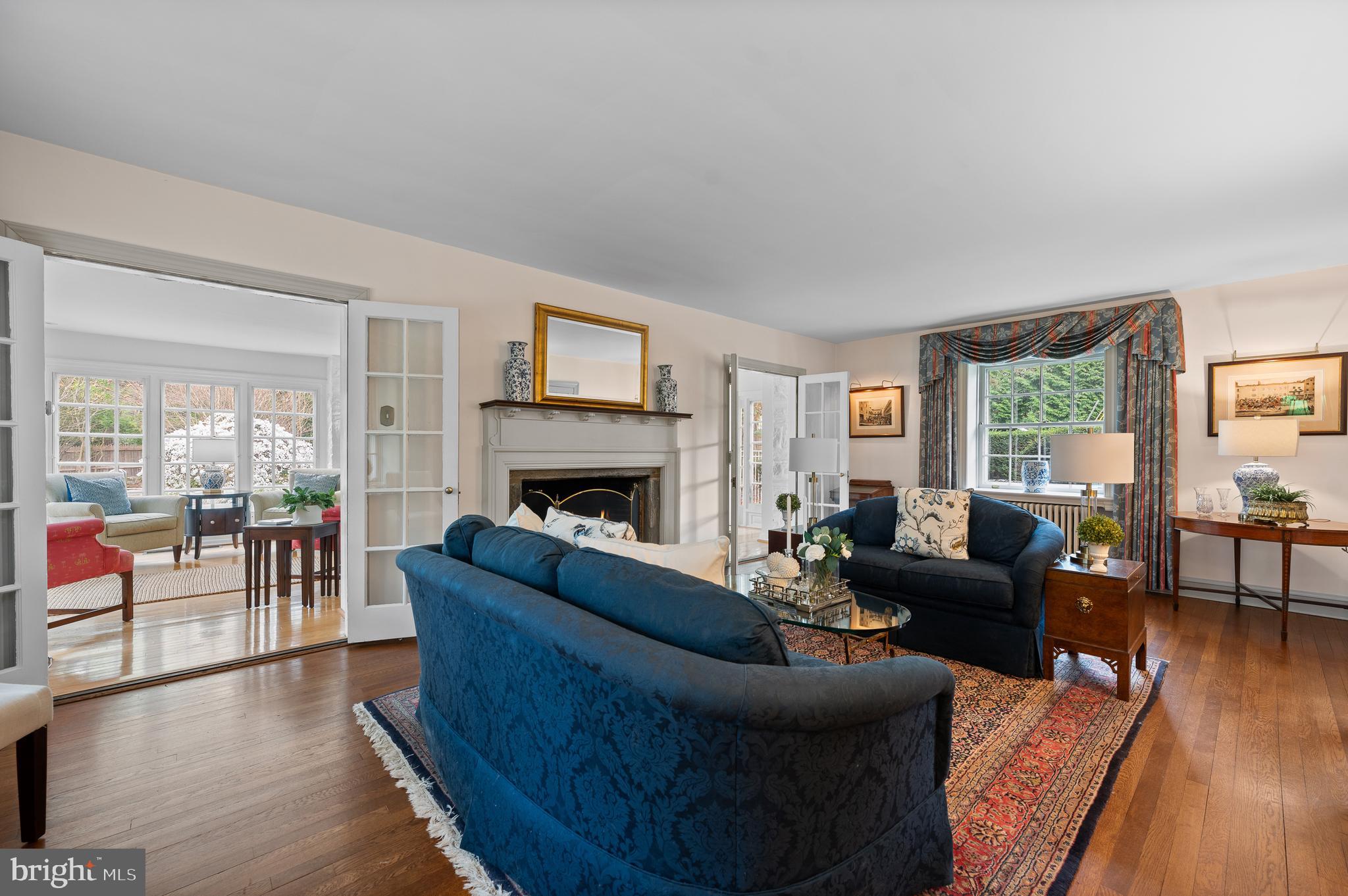 3 Canterbury Lane Wayne, PA 19087 - Photo 10 of 57 a living room with furniture a fireplace a flat screen tv and wooden floor