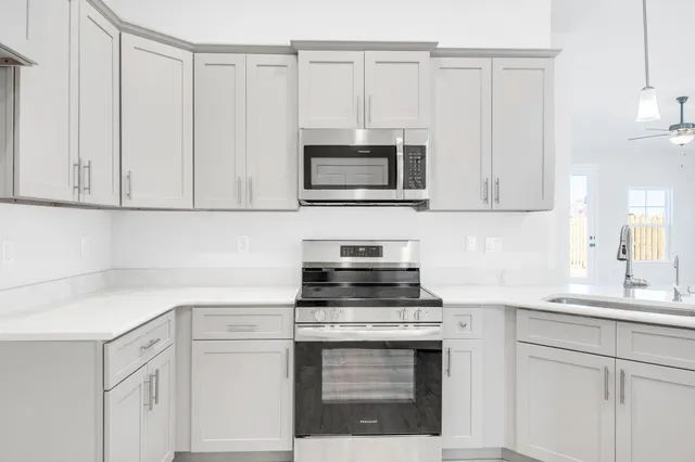 a kitchen with granite countertop white cabinets and a stove