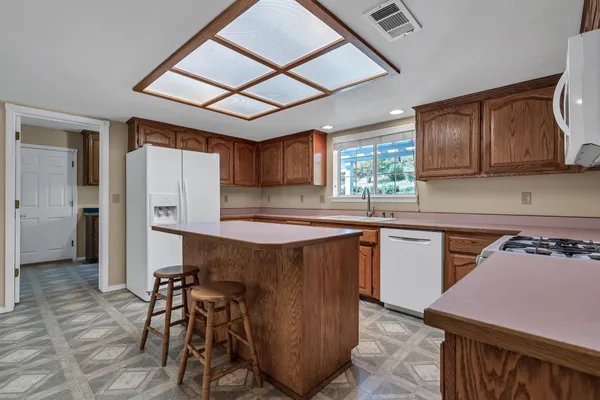 a kitchen with stainless steel appliances granite countertop a stove a refrigerator and a microwave