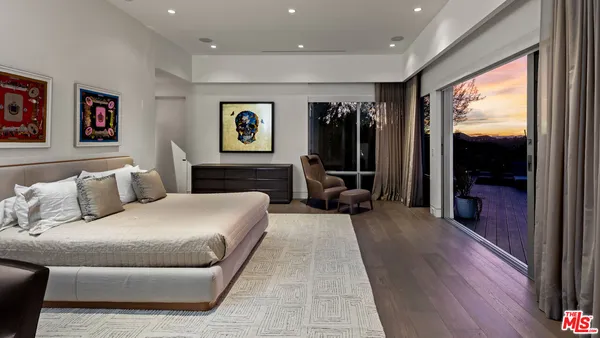 a bedroom with a large bed and a flat tv screen