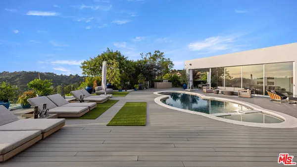 a view of a swimming pool with couches and lounge chairs