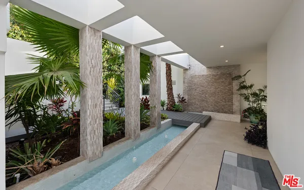 a lobby with furniture and potted plants