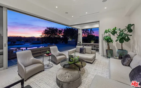 a living room with furniture flowers and a flat screen tv