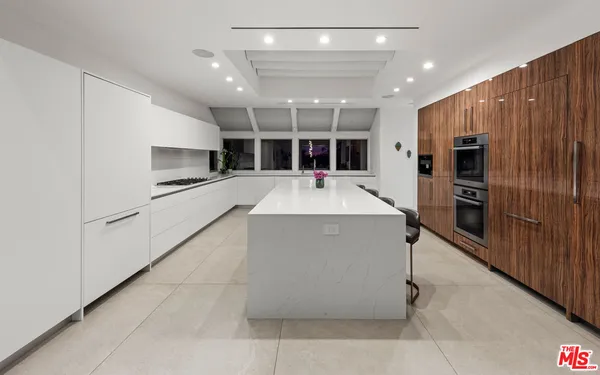 a large kitchen with stainless steel appliances kitchen island a large counter top and a stove top oven