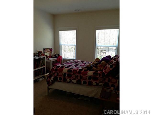 5000 Fallondale Road, Unit 885 Waxhaw, NC 28173 - Photo 13 of 16 a bed sitting in a bedroom next to a window