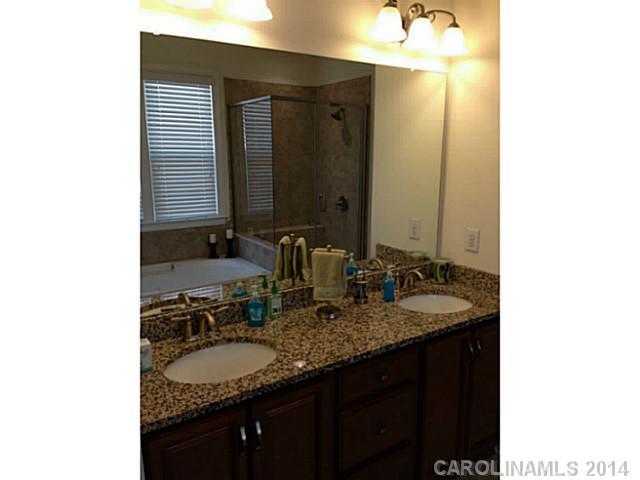 5000 Fallondale Road, Unit 885 Waxhaw, NC 28173 - Photo 10 of 16 a bathroom with a granite countertop sink and a mirror