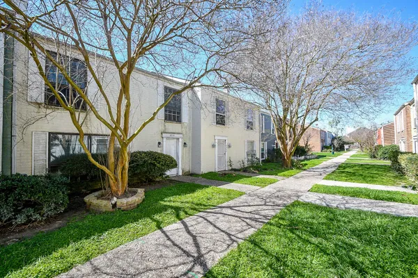 a white house that has a tree in front of it