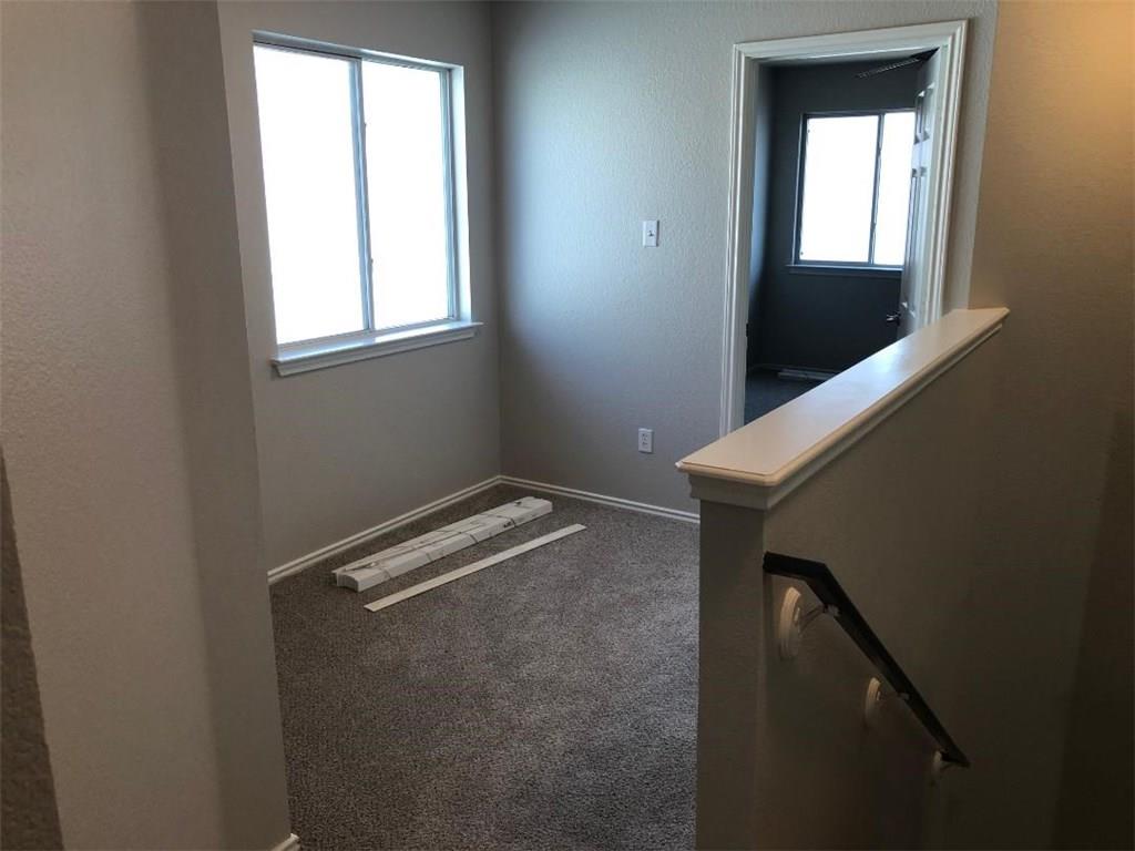 9217 Rowlands Sayle Road Austin, TX 78744 - Photo 6 of 18 Natural light fills this versatile upper landing area complete with carpet flooring.