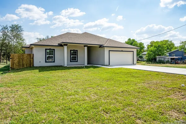 a front view of a house with yard and green space