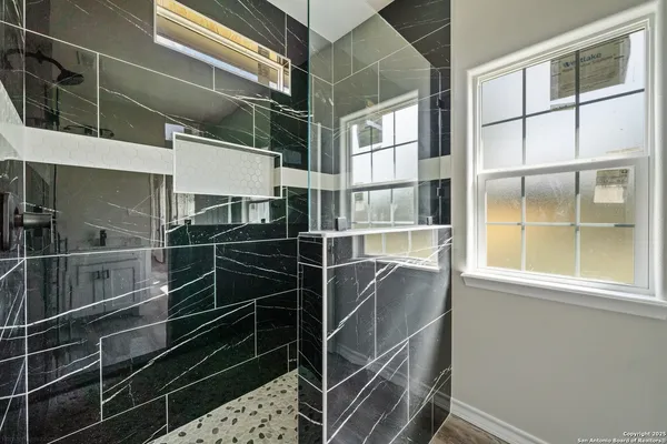 a spacious bathroom with a double vanity sink a mirror and a shower
