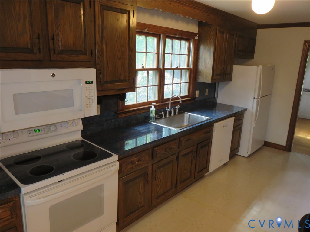 8379 Quailfield Road Mechanicsville, VA 23116 - Photo 22 of 56 a kitchen that has a sink a stove and a refrigerator