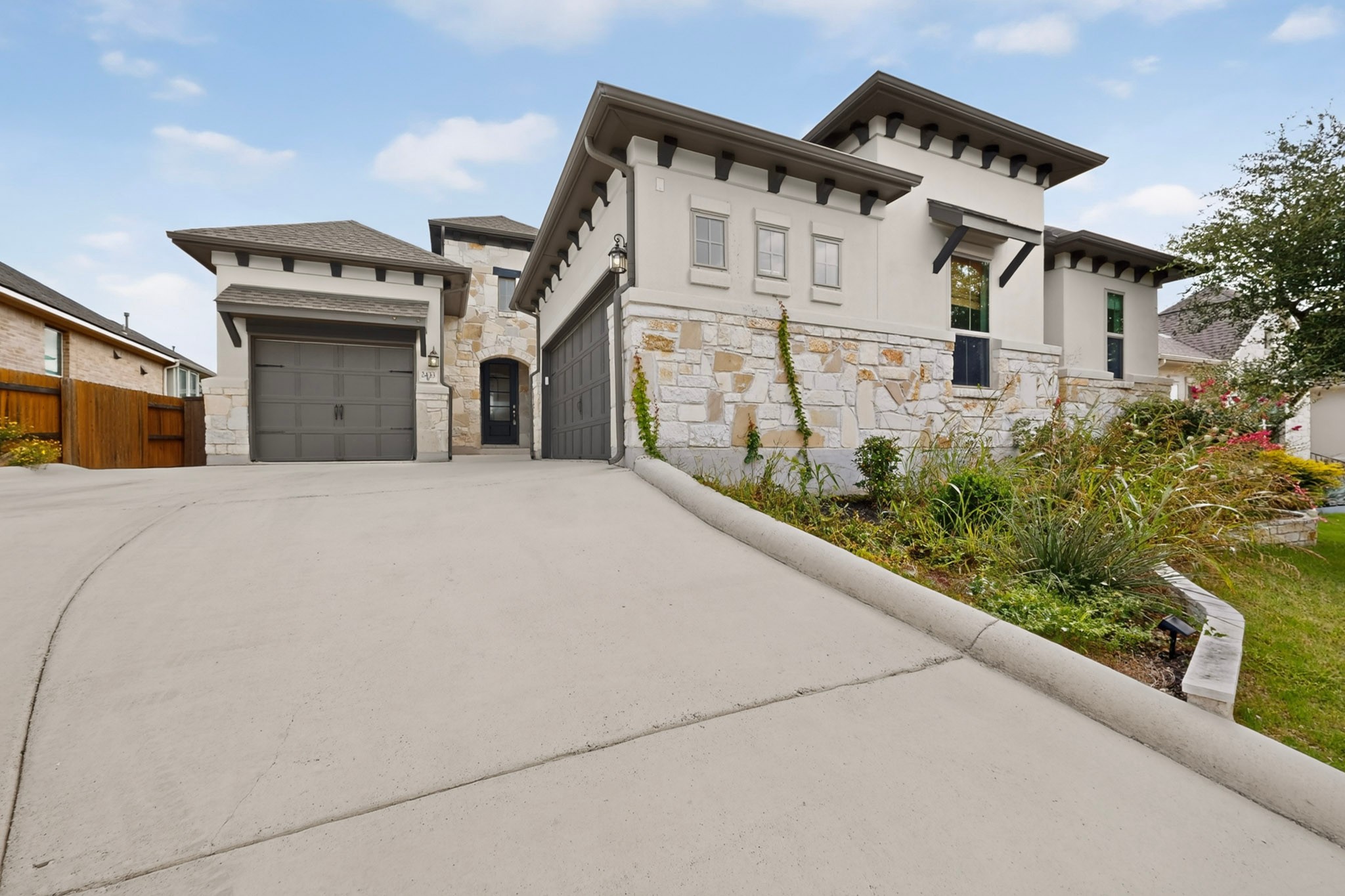 2433 La Mirada Street Leander, TX 78641 - Photo 2 of 25 Two garages and stone accents define this inviting contemporary home's facade.