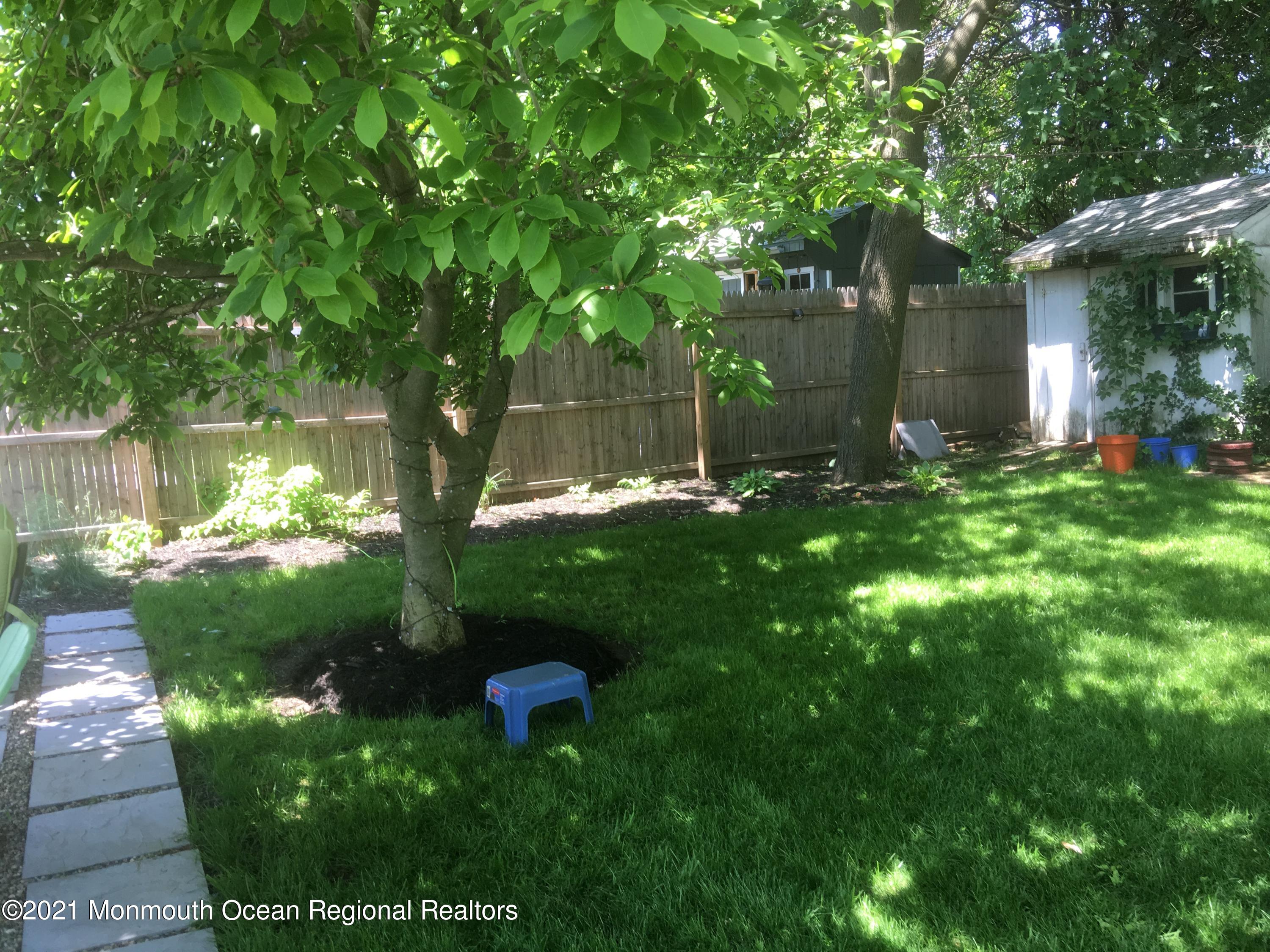 104 Bank Street Red Bank, NJ 07701 - Photo 29 of 33 a backyard of a house with lots of green space and fountain