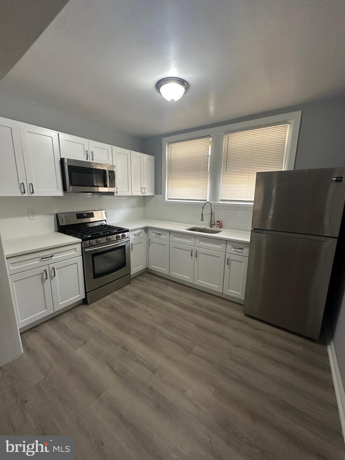 5935 Agusta Street Philadelphia, PA 19149 - Photo 4 of 13 a kitchen with a sink a refrigerator and a stove top oven