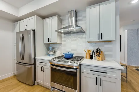 a kitchen with stainless steel appliances a stove a refrigerator and cabinets
