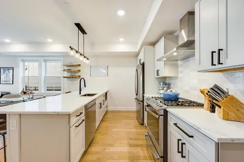 a kitchen with stainless steel appliances a sink stove and cabinets