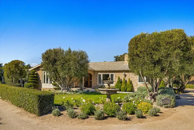 a front view of a house with a garden