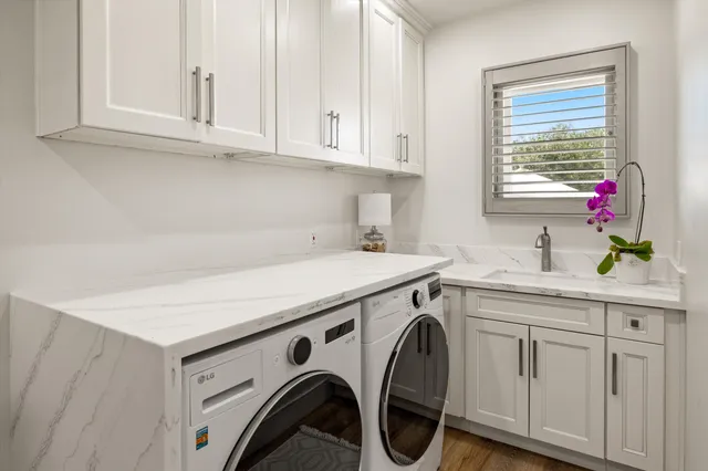 a dining room with furniture a rug a potted plant and a chandelier
