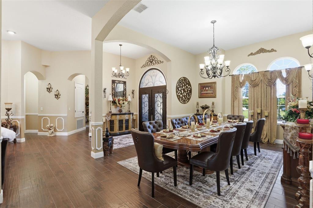 13429 Montevista Road Clermont, FL 34711 - Photo 11 of 89 a view of a dining room with furniture a chandelier and wooden floor
