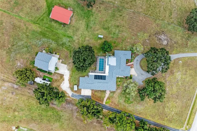 an aerial view of a house with swimming pool and sitting space