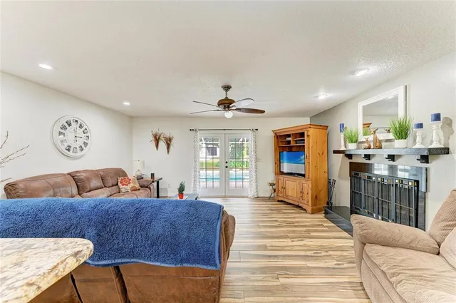 a kitchen with stainless steel appliances a sink a stove a refrigerator cabinets and living room view