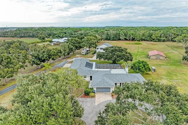 a living room with furniture a flat screen tv and a floor to ceiling window
