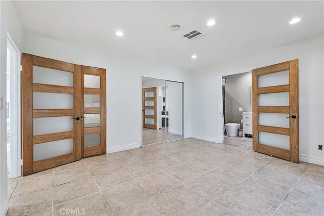 a bedroom with a large bed and a potted plant