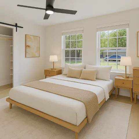 a bedroom with a bed and a large window